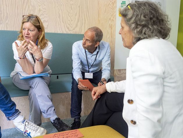 Workshopteilnehmende sitzen zusammen und diskutieren. 